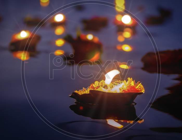 At early sunset and sunrise beautiful floating garlands of flowers and floating candles placed by pilgrims on the river Ganges as offerings.