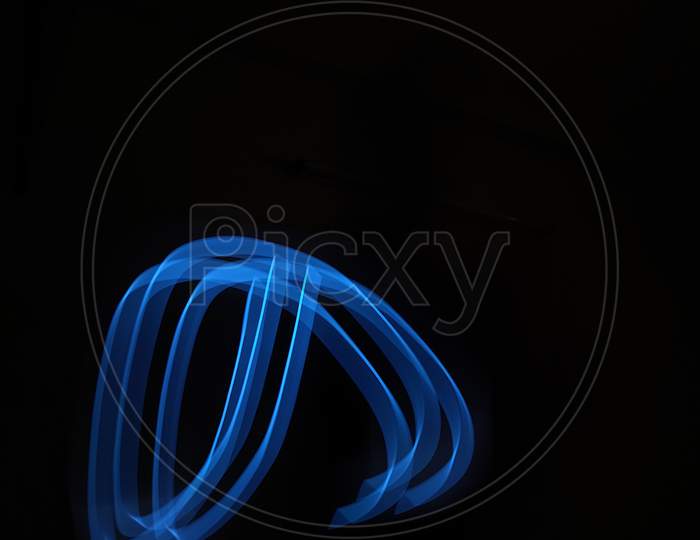 Light painting photography, long exposure, ripple circle and waves against black background