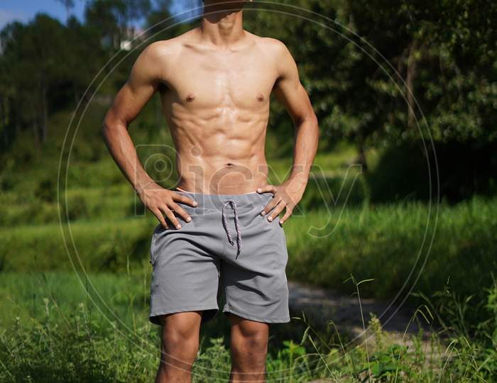 Young Handsome Shredded Boy Standing Shirtless On The Pathway. Fitness And Health.