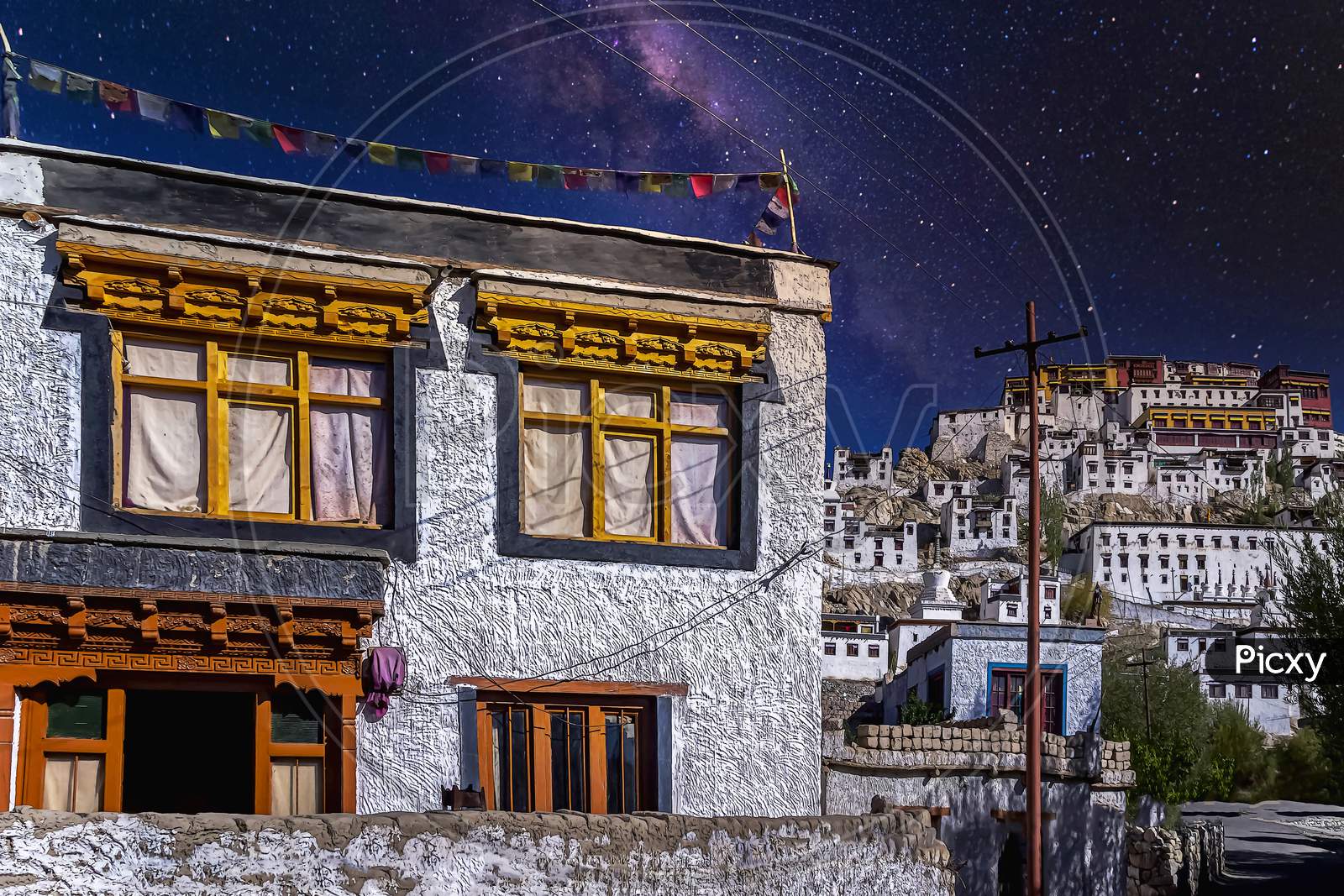 A white painted buddhist home under a starry sky as seen at the Thikse Monastery village near Leh city, Ladakh, India