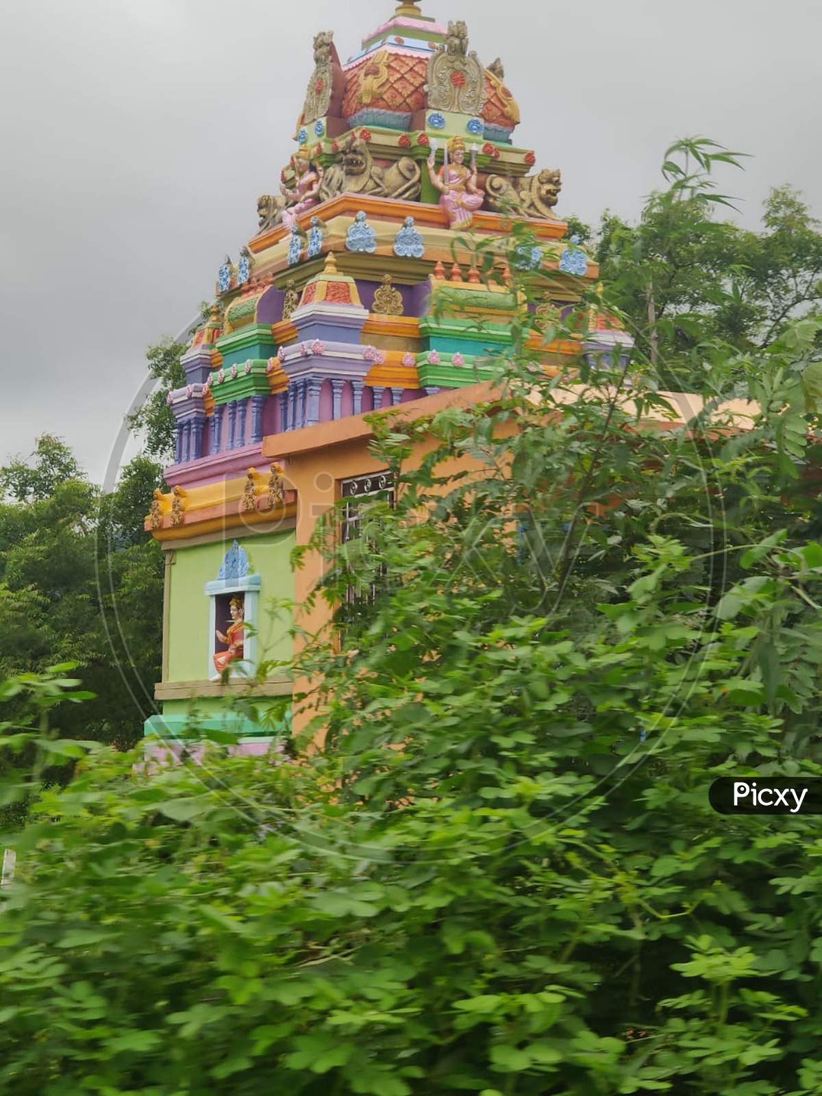 Small colourful Indian temple in agriculture farms in village