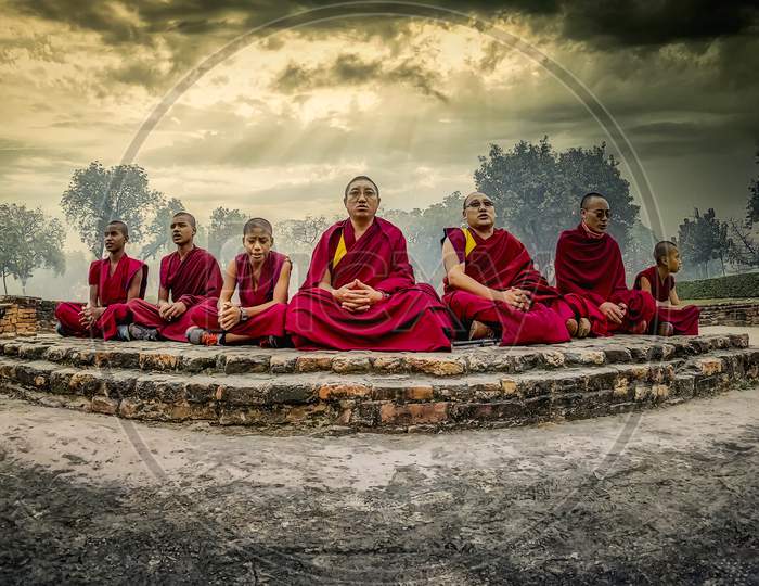 Buddhist monks in meditating at the holy place at the deer park in Sarnath where Gautama Buddha first taught the Dharma, and where the Buddhist Sangha came into existence.