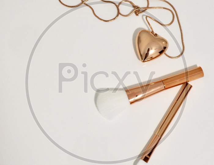 Photo of Gold Make-up Brushes and Necklace.