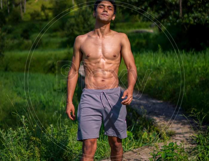 Young Handsome Shredded Boy Walking Shirtless On The Pathway. Fitness And Health.