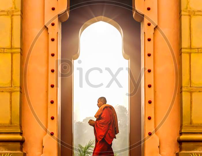 A Dharma Buddhist monk in a temple doorway at the spiritual city of Sarnath, India