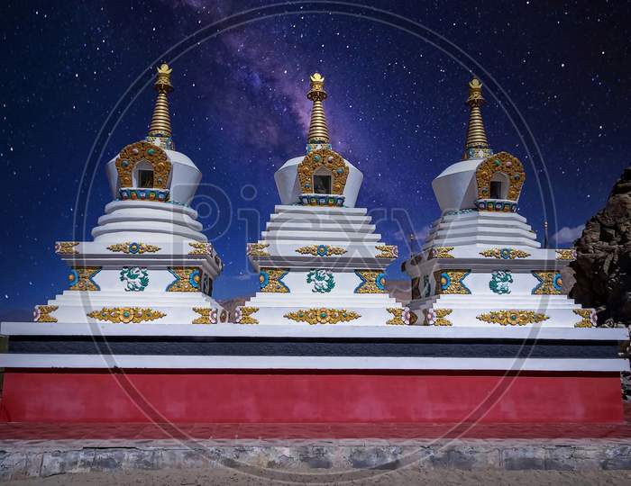 White painted stupas holding buddhist relics under a starry sky as seen at the Thikse Monastery near Leh city, Ladakh, India