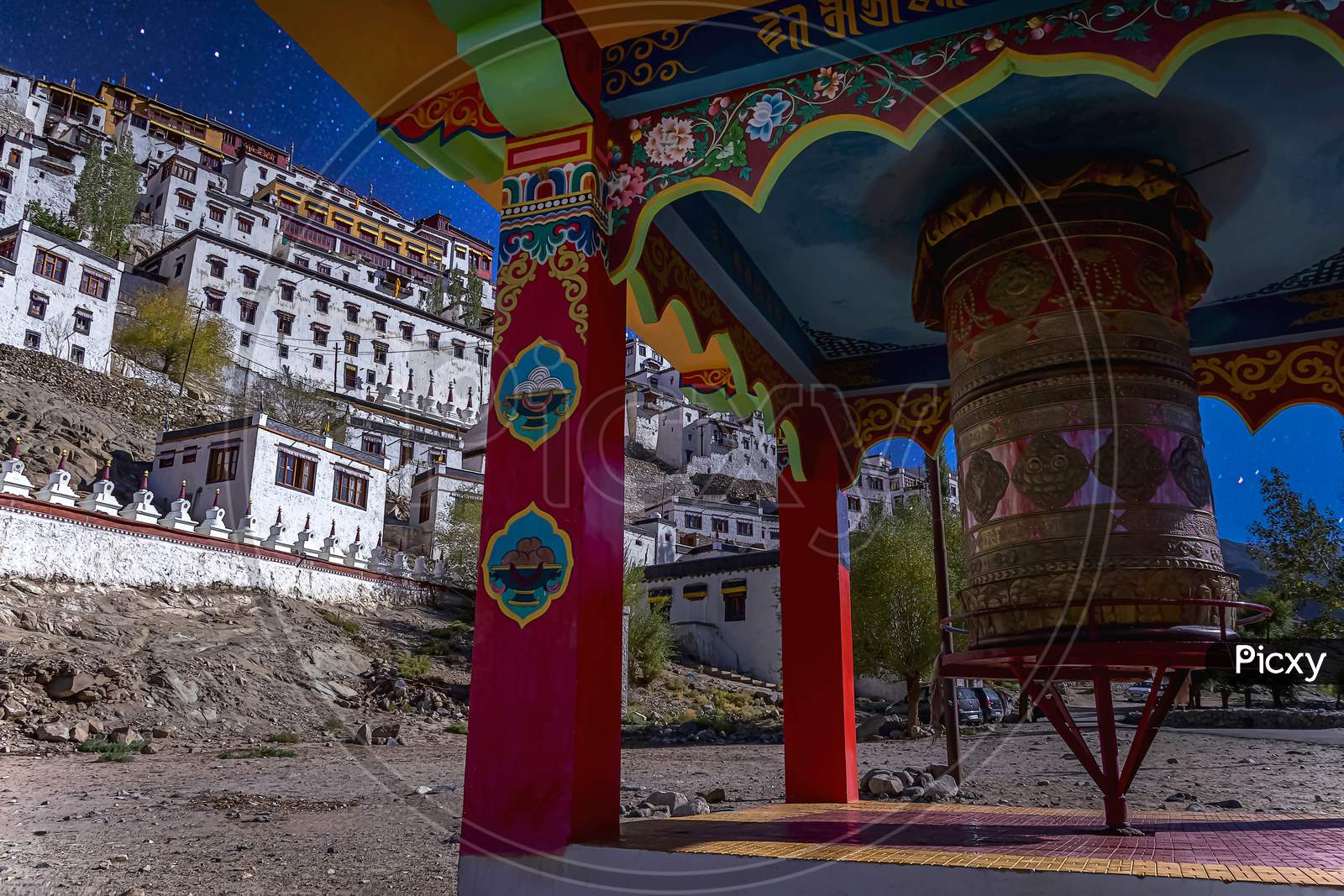 The big colourful buddhist prayer wheel under a starry sky as seen at the Thikse Monastery near Leh city, Ladakh, India