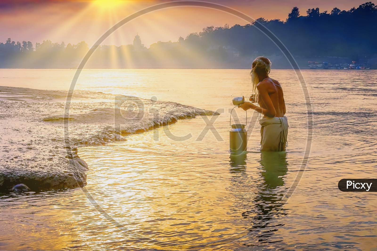 A pilgrim bathing in the holy waters of the Ganges at Rishikesh a city in India’s northern state of Uttarakhand, in the Himalayan foothills beside the Ganges River.
