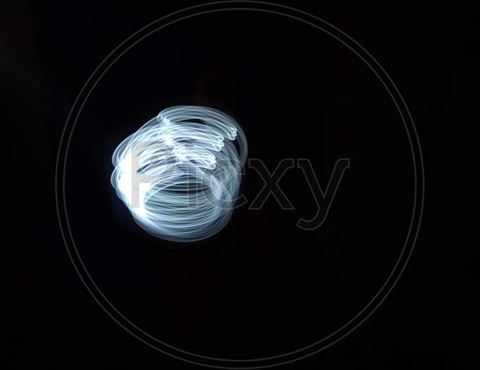 Light painting photography, long exposure, ripple circle and waves against black background