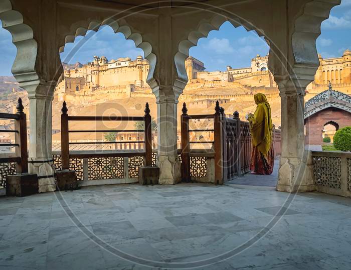 A visitor admiring the beautiful architecture of the Amer Fort or Amber Fort is a fort located in Amer, Rajasthan, India.