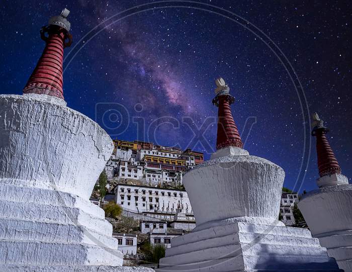 Two White painted stupas under a starry sky as seen at the Thikse Monastery near Leh city, Ladakh, India