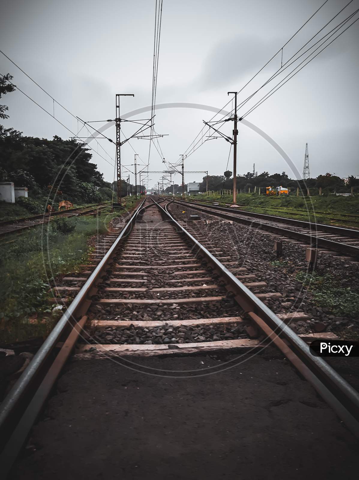 A landscape photo of railway line and some electric wires.