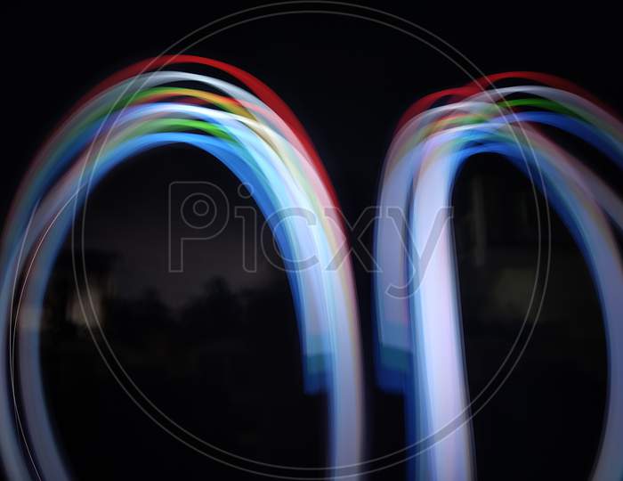 light painting photography, long exposure, ripple circle and waves against black background