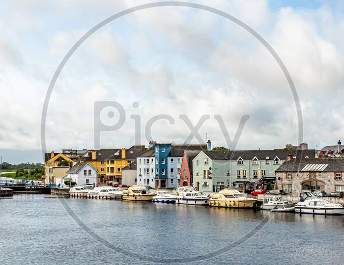 View Of The River Shannon With Boats Anchored On The Coast And The Town Of Athlone With Picturesque Houses, Wonderful And Relaxed Day In The County Of Westmeath, Ireland