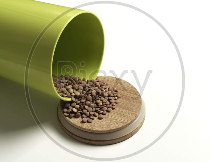 Lentils Spilling Out Of A Lying Pot With A White Background. Product Photography