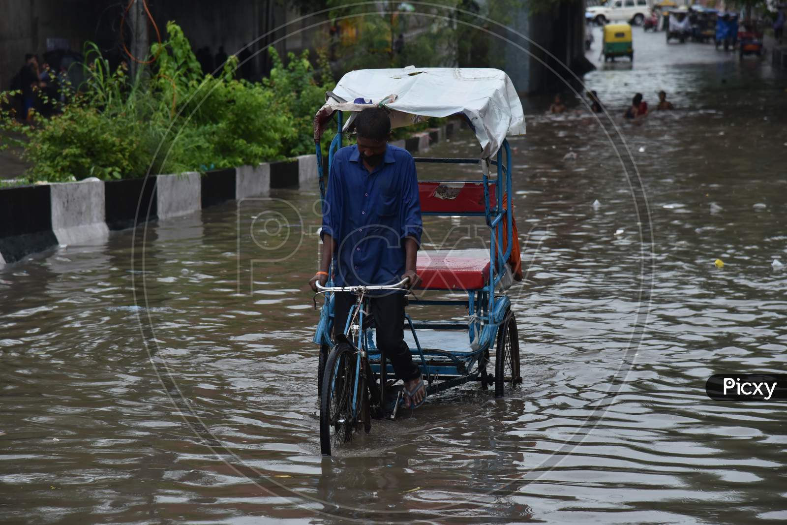 A man crosses a flooded street during heavy rains in New Delhi, India, August 19, 2020.