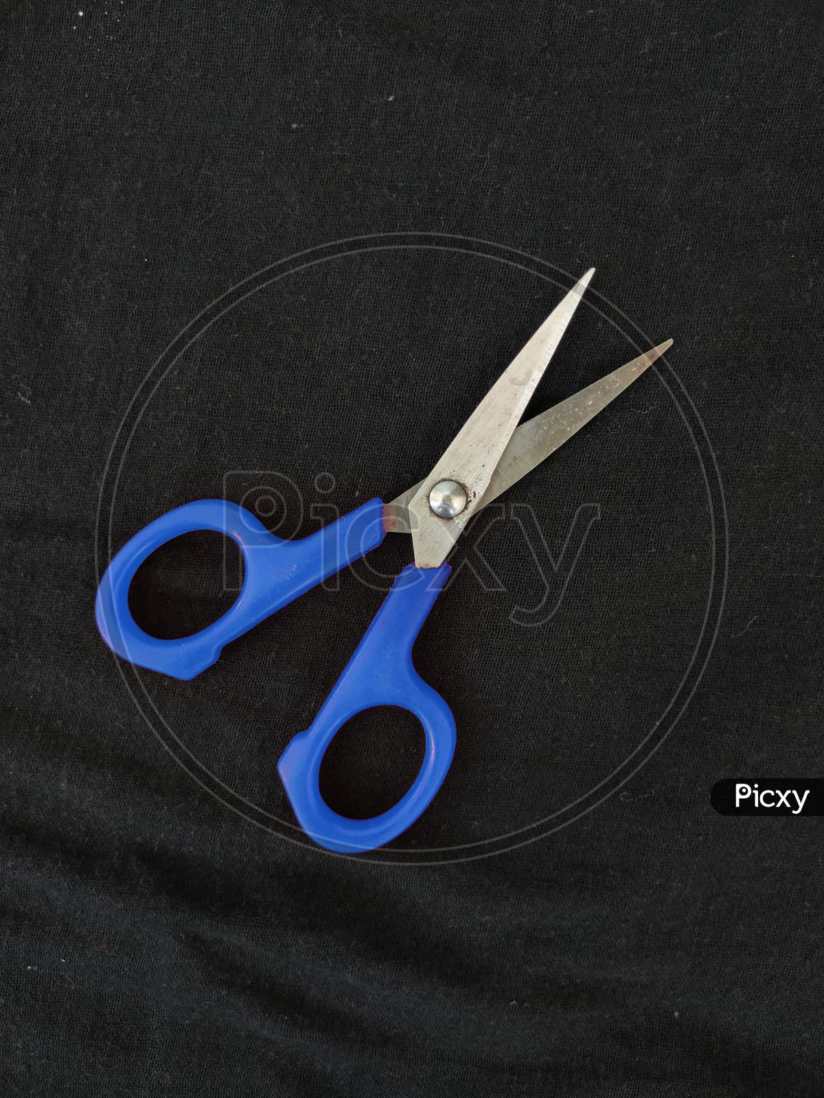 Steel And Blue Color Small Single Scissor Isolated On Black Background
