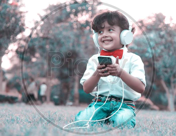 Beautiful Fashionable Boy Listening Music In Headphone From Smartphone .