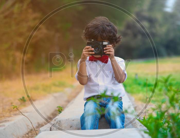 Portrait Of Young Boy Capturing Photo In Old Camera.