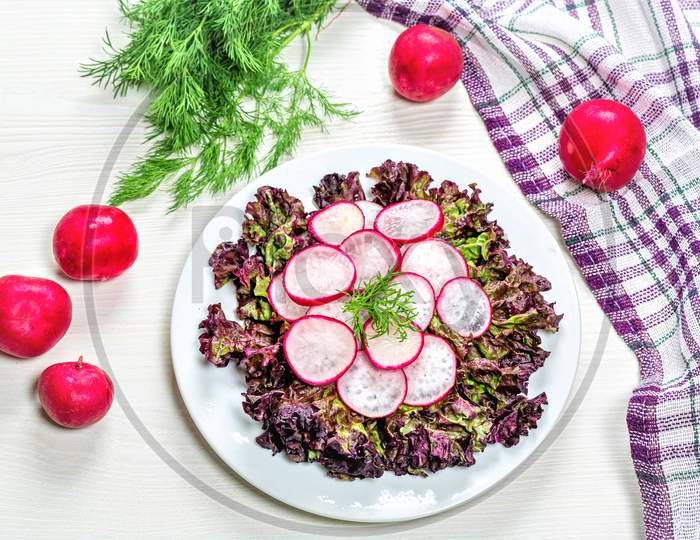 Diet Salad With Radishes And Lettuce On A White Wooden Background. The View From The Top