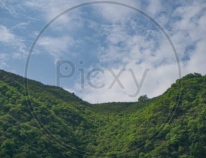 Landscape Of A Green Mountain Valley Covered With Clouds.