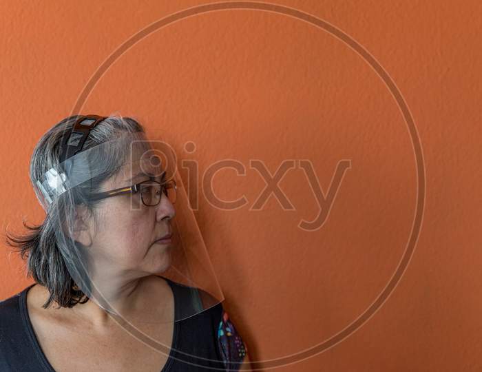 Face Shield Or Protective Mask On A Mature Woman Wearing Glasses To Prevent The Spread Of Covid-19 Amid The Coronavirus Outbreak, New Lifestyle, Side View