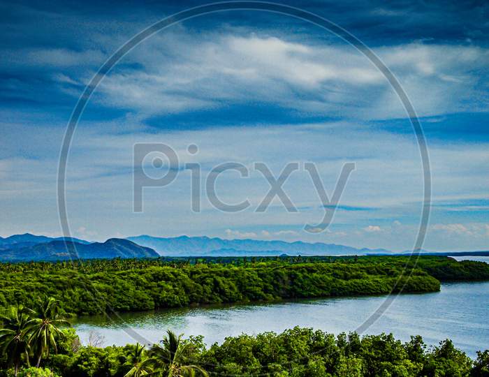 Cuyutlan Lagoon Surrounded By Tropical Vegetation, Spring Day With A Cloudy Sky With Abundant Clouds In Manzanillo, Colima Mexico