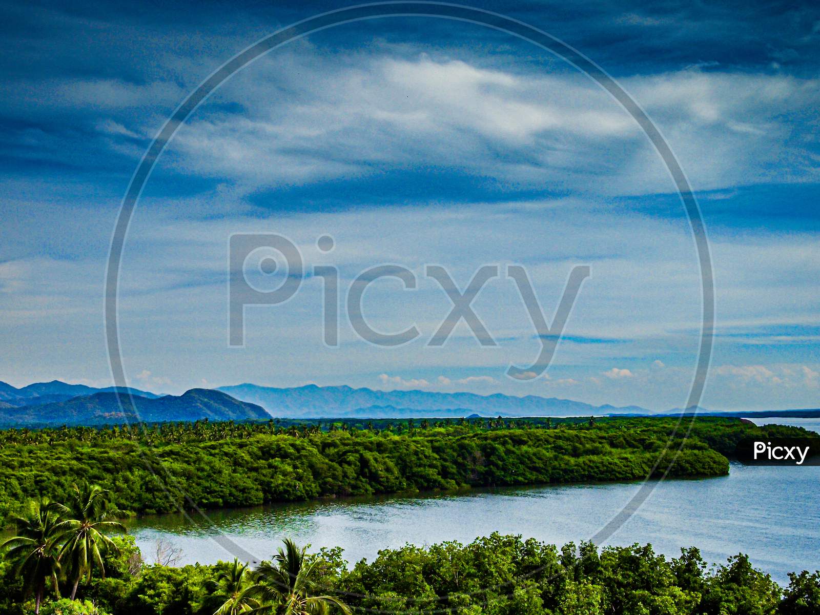 Cuyutlan Lagoon Surrounded By Tropical Vegetation, Spring Day With A Cloudy Sky With Abundant Clouds In Manzanillo, Colima Mexico