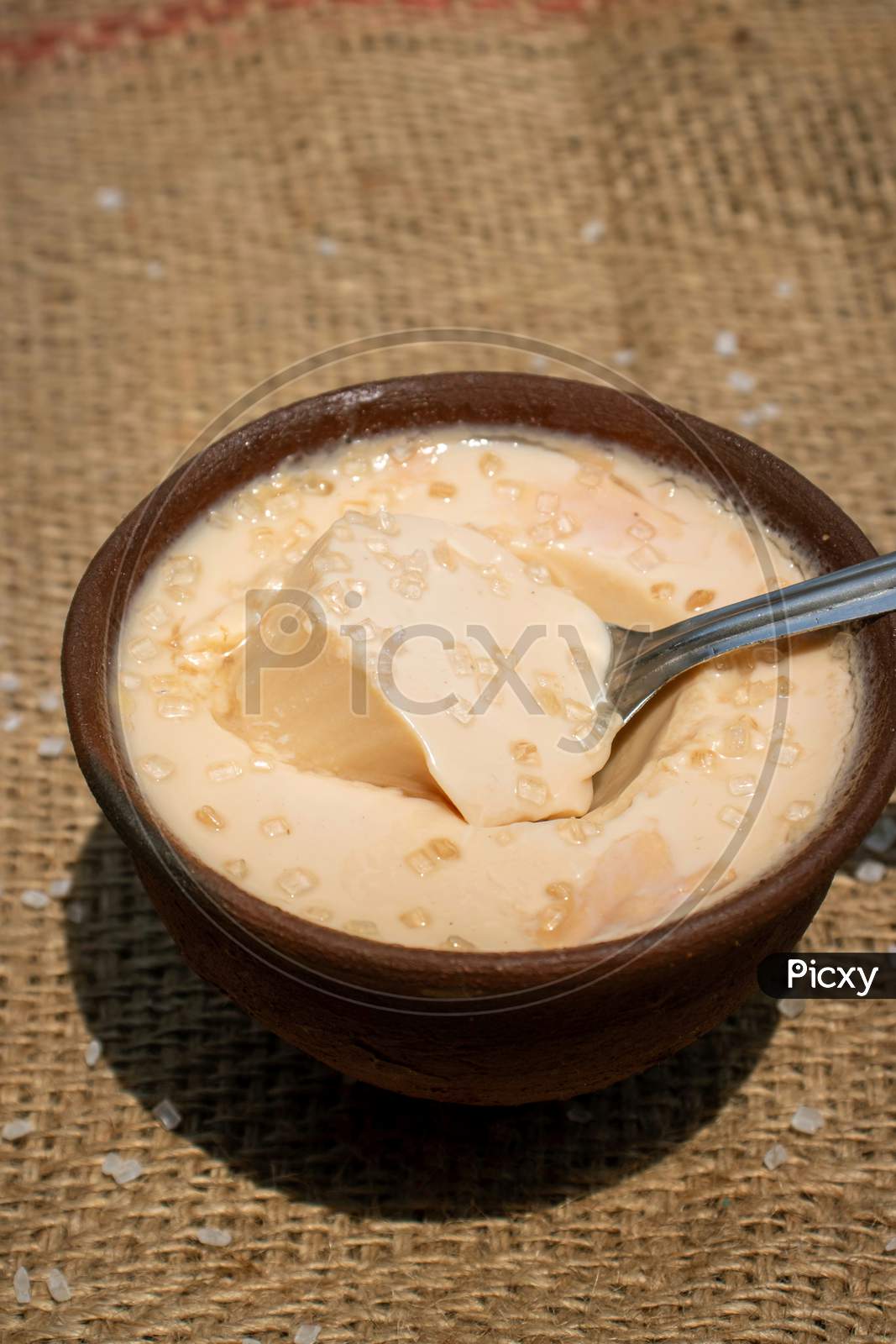Curd Or Dahi (Yogurt) In An Earthen Bowl With Spoon And Selective Focus In Vertical Orientation