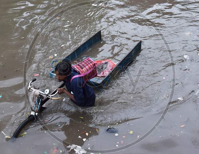 A man crosses a flooded street as he drags his hand cart during heavy rains in New Delhi, India, August 19, 2020.