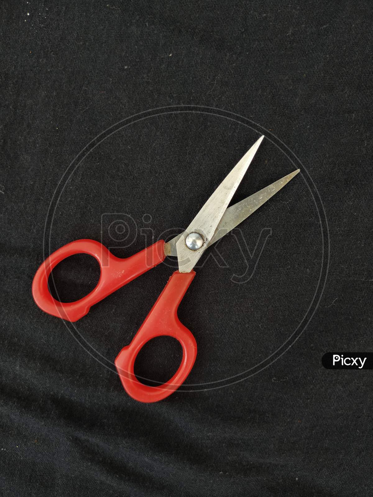 Steel and Red Color Small Single Scissor isolated on black Background