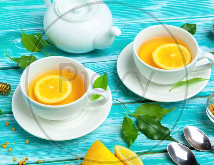 Yellow Lemons Tea In Kettle Cup Spoon Saucer Image.