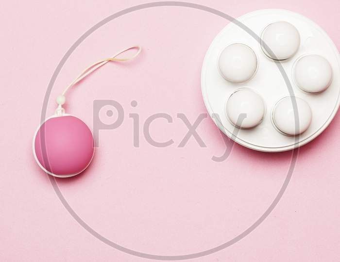 Weights And Ball For Pelvic Floor In Pink Background. Flat Lay.