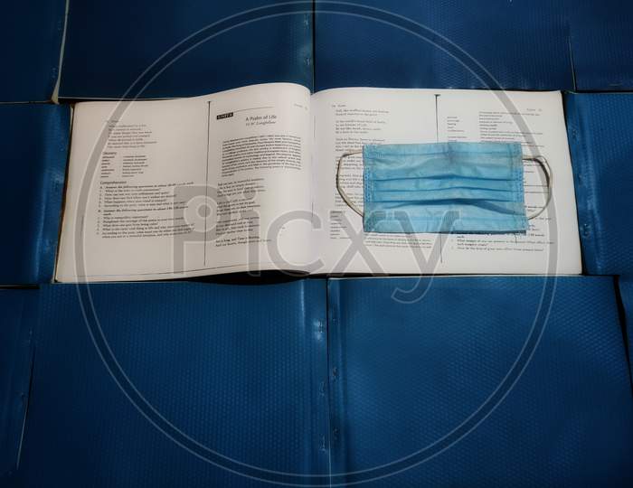 Book with blue medical mask , life of student in covid19