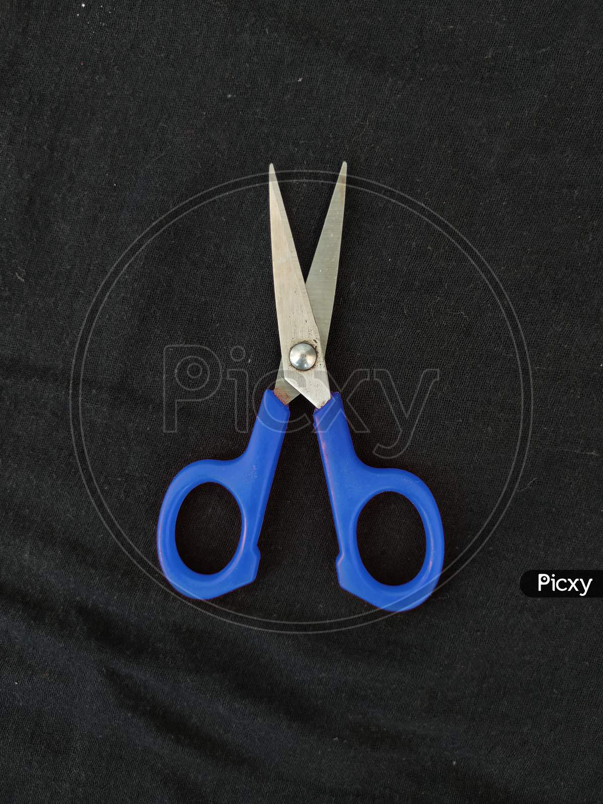 Steel And Blue Color Small Single Scissor Isolated On Black Background