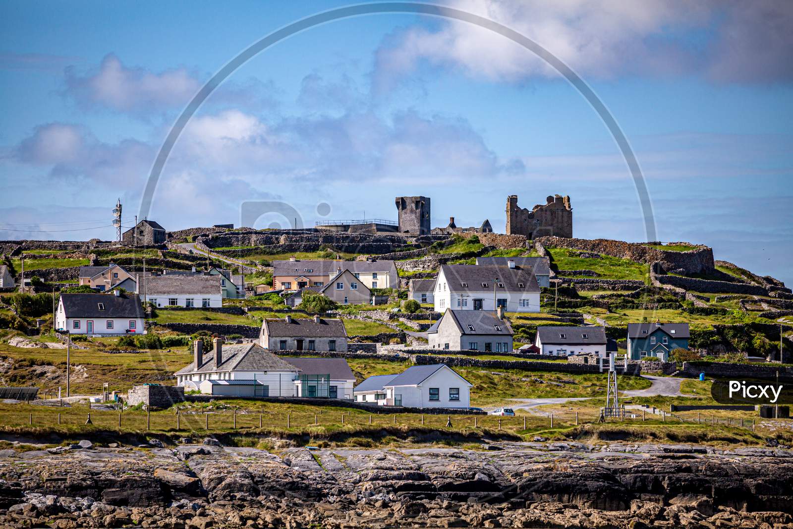 Beautiful View Of The Ruined 15Th Century Castle In A Prehistoric Stone Fort And Houses On The Inis Oirr Island Seen From A Boat, Wonderful Sunny Day In The Aran Islands, Ireland
