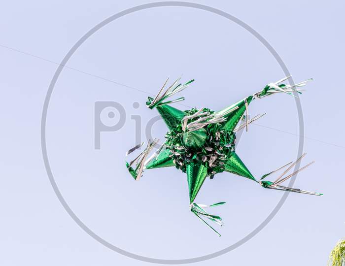 Metallic Green Paper Piñata Suspended In The Air With A Blue Sky Background, Wonderful Mexican Tradition