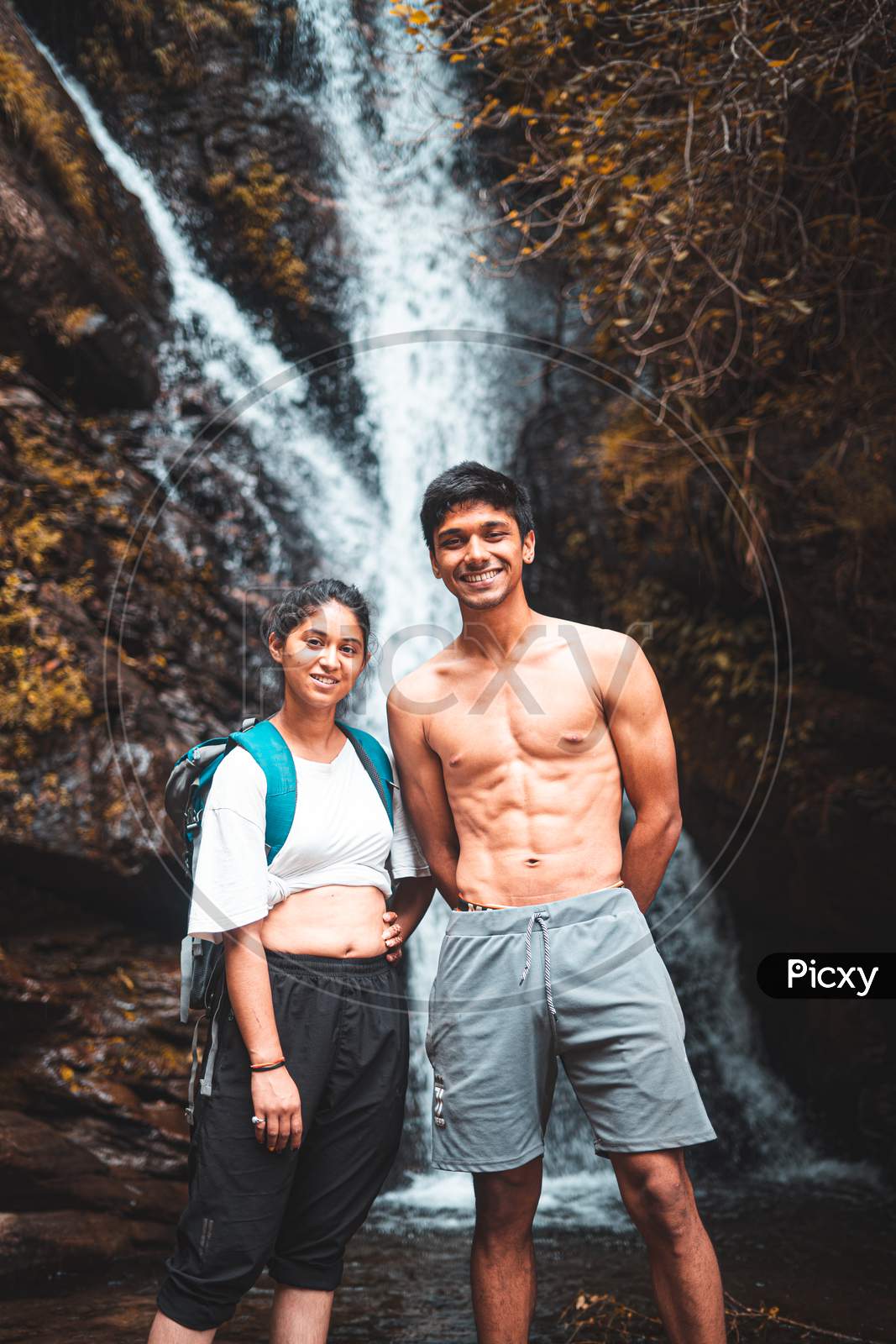 Young Couple Enjoying The Beautiful Waterfall View.