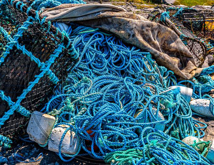 Accumulation Of Marine Litter, Such As Fishing Nets, Ropes, Lobster / Crab Cages Or Fishing Traps On The Rocky Coastal Beach Of The Island Of Inis Oirr, Sunny Day On The Island Of Inisheer In Ireland