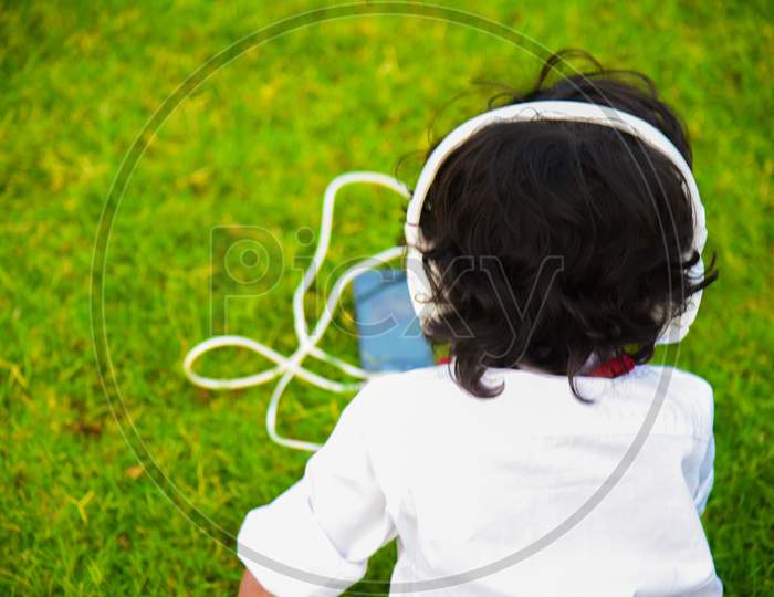 Boy Listening Music In Big White Head Phone .