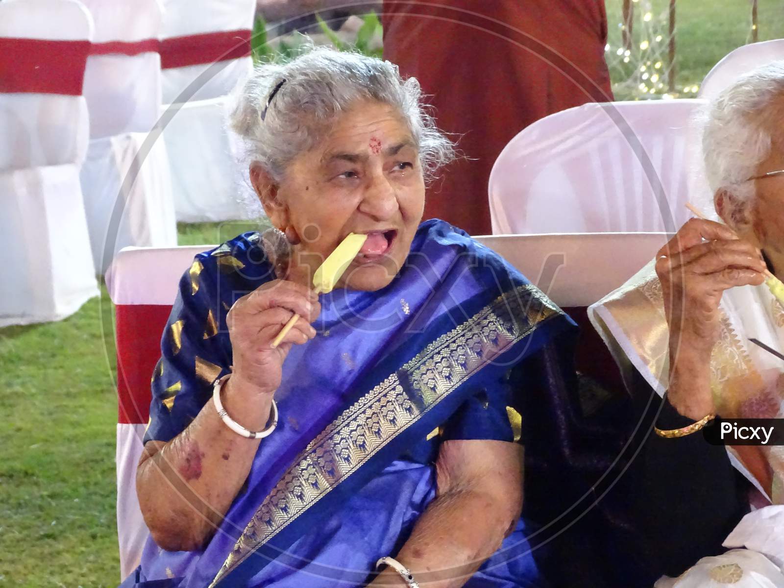 Old Indian woman having kulfi