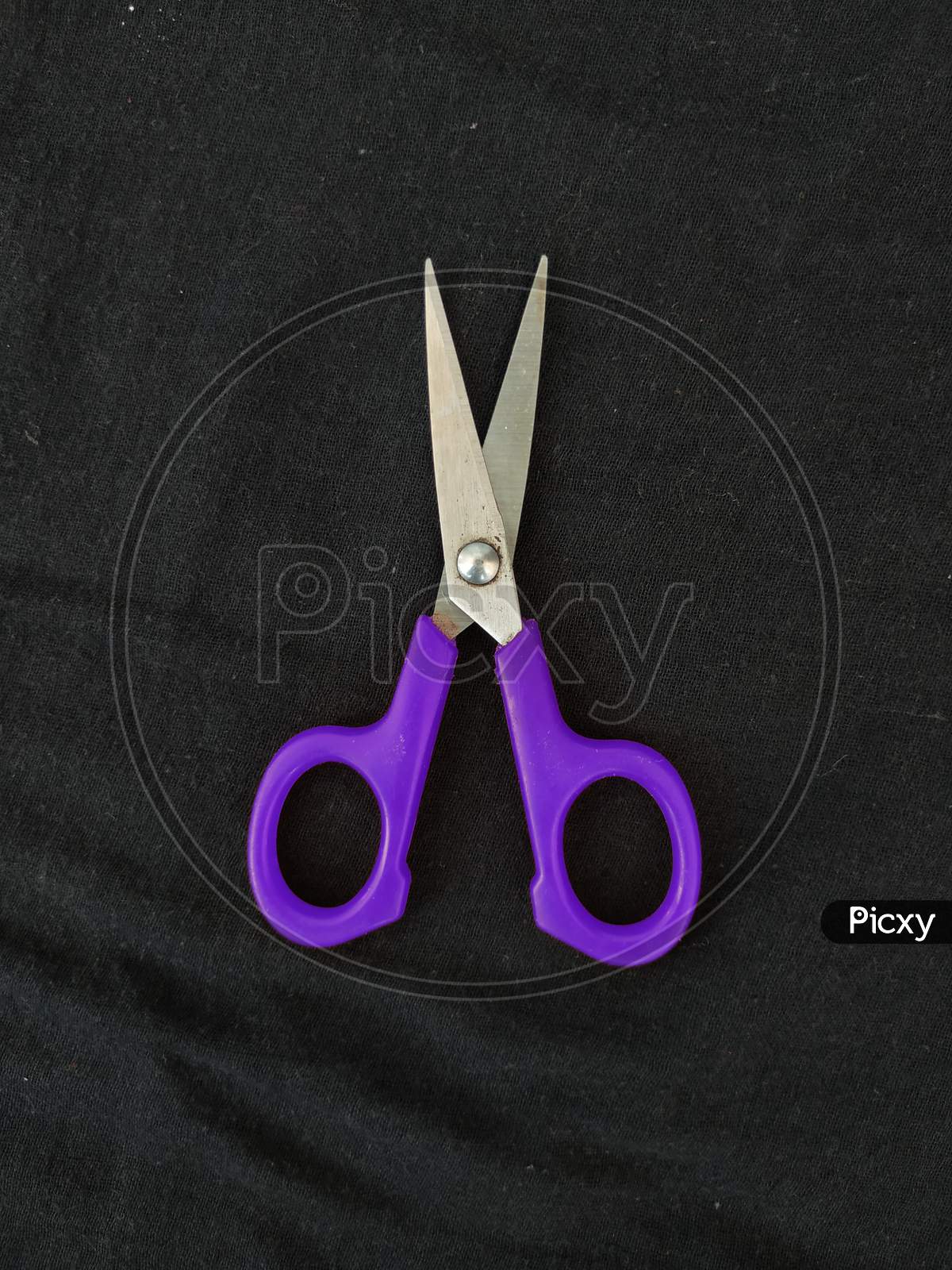 Steel And Purple Color Small Single Scissor Isolated On Black Background