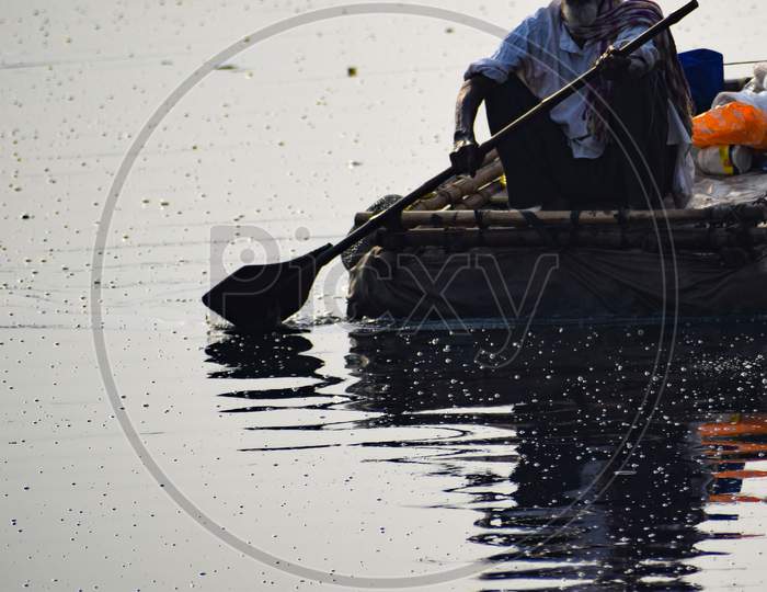 New Delhi, India - March 04, 2020: A Man Paddling A Boat During Morning Time At Yamuna River Ghat In New Deli, India