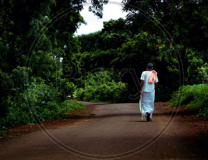 Old man walkng on a road near shankarpally
