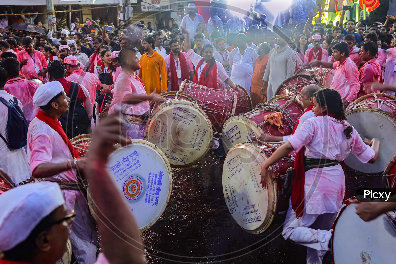 A group of devotees beating drums during the festival of an Indian God Ganesh Puja