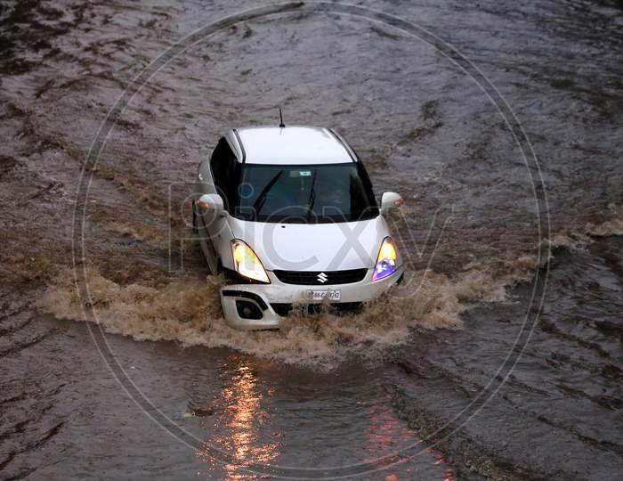 People drive through a flooded road during heavy rains in Ajmer, On August 1, 2020.