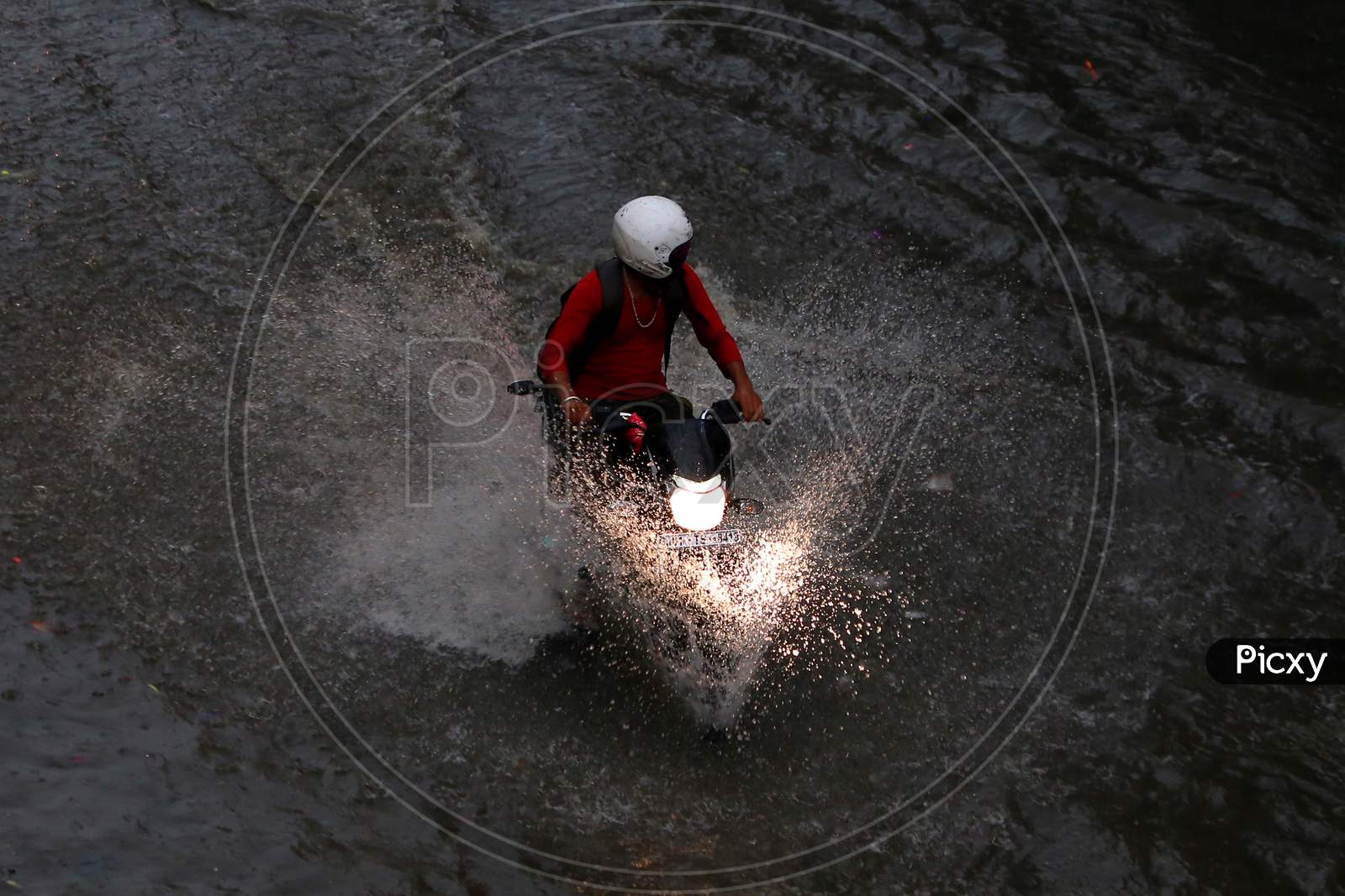 A man drives through a flooded road during heavy rains in Ajmer, On August 1, 2020.