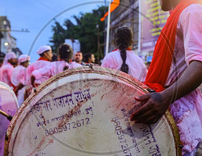 A group of men playing dhol a musical instrument in a religious procession of Ganesh visarjan