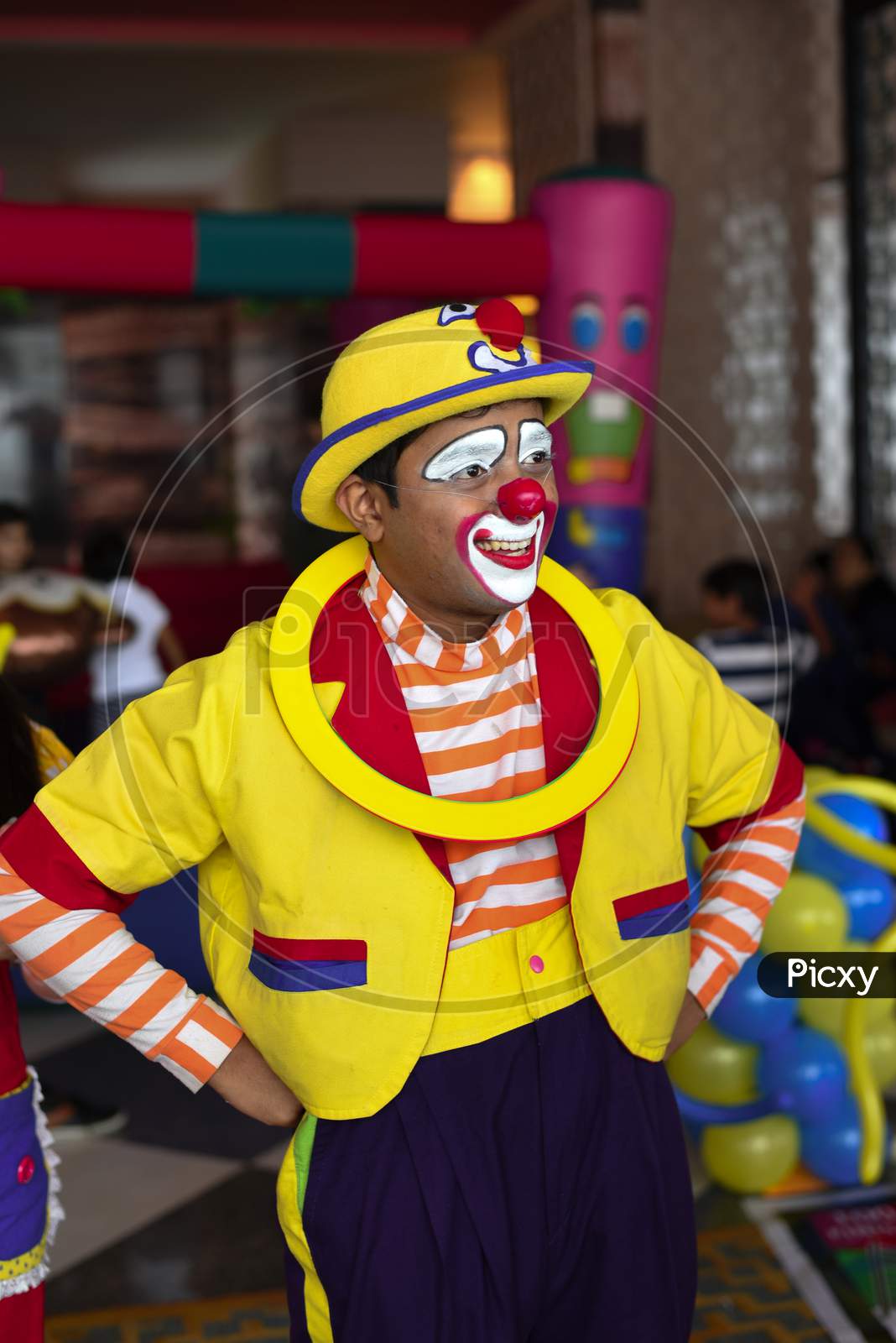 A clown in a pink and yellow suit