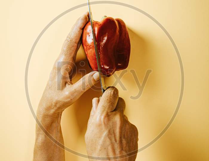 Old Woman Hands Grabbing A Pepper And A Knife